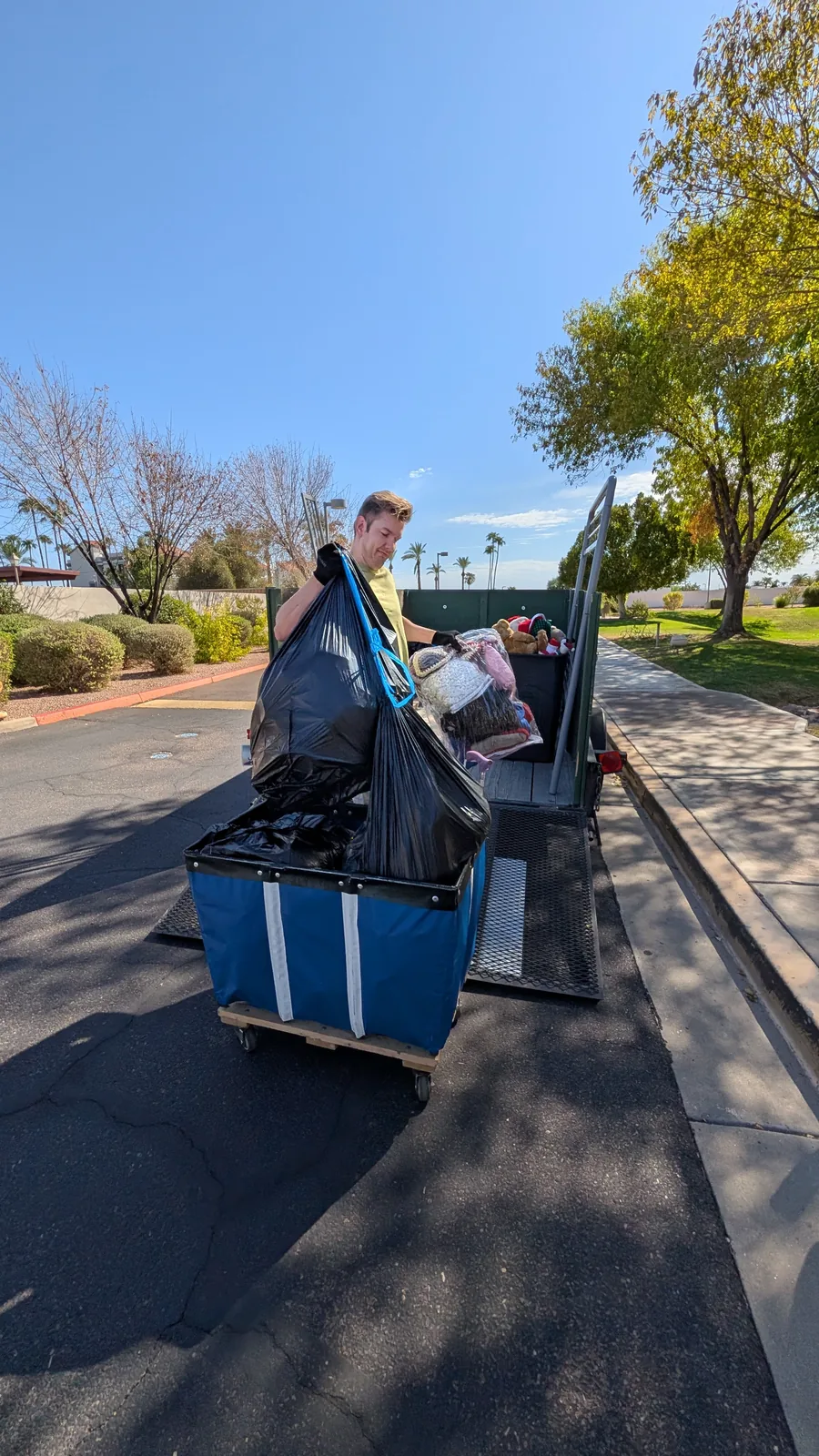 Rolling bin of household items beside the trailer during a Sun City cleanout