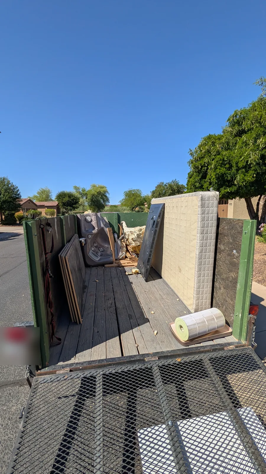 Dismantled hot tub sections and a mattress staged in a Peoria trailer