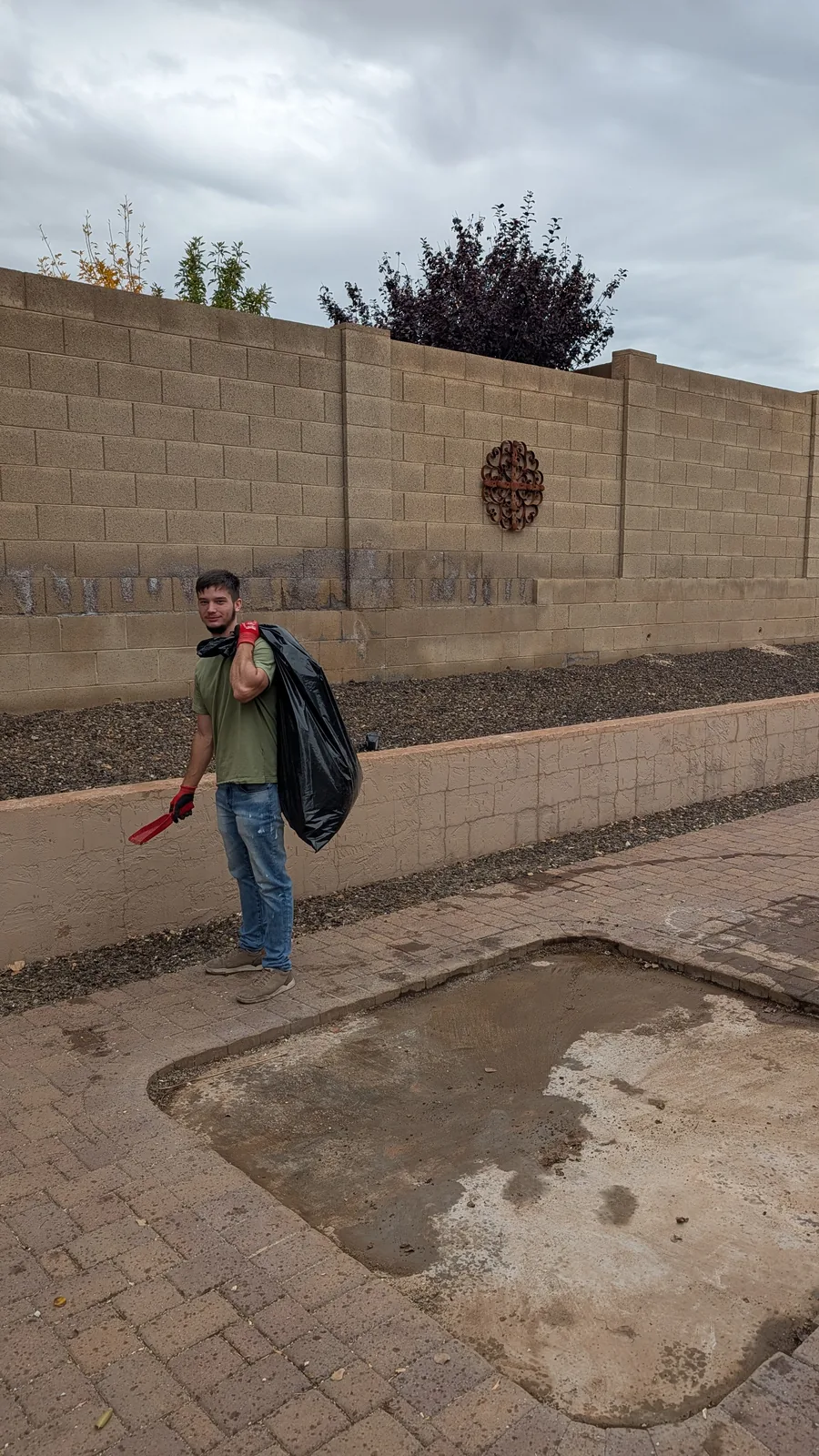 Crew member beside the cleared hot tub footprint in North Phoenix
