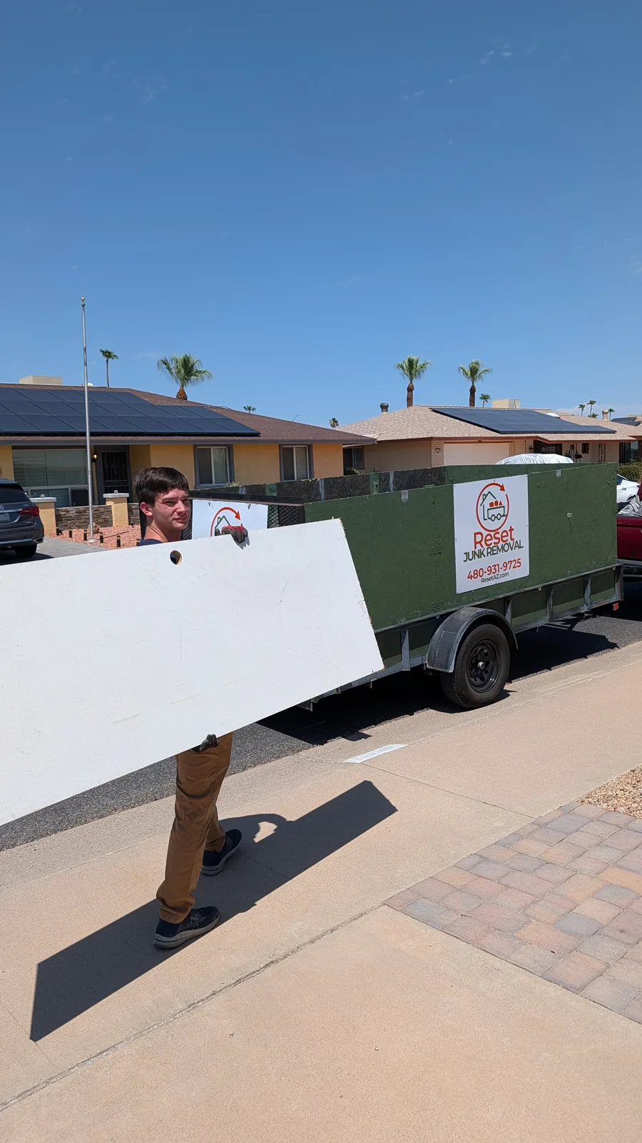 Large household panel being carried during a Sun City junk pickup