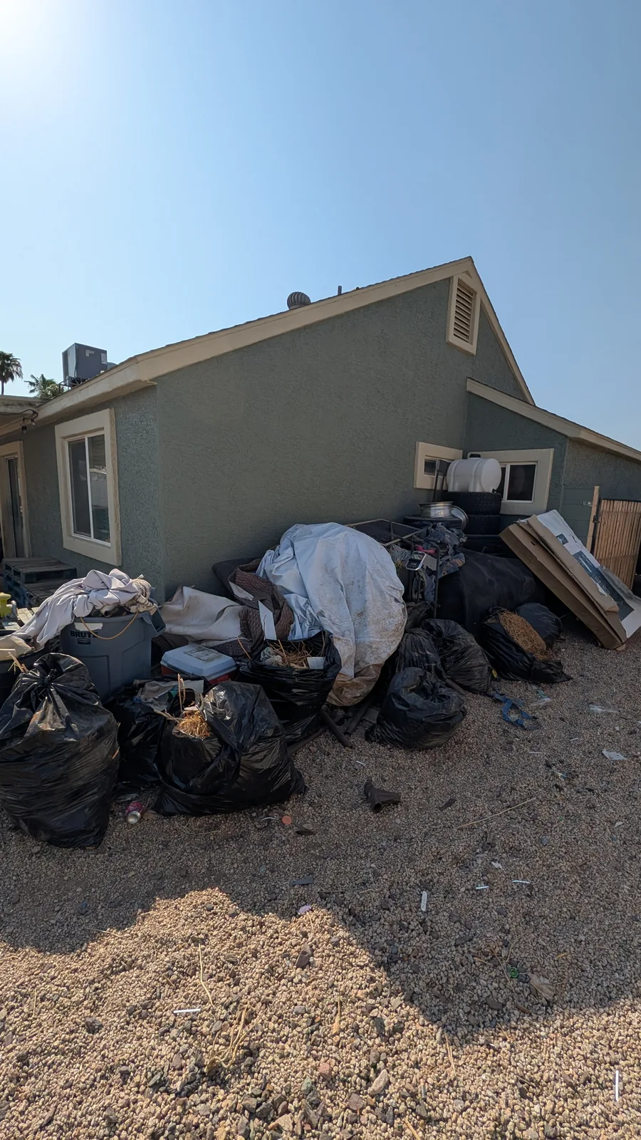 Large mixed junk pile beside a Peoria home before removal