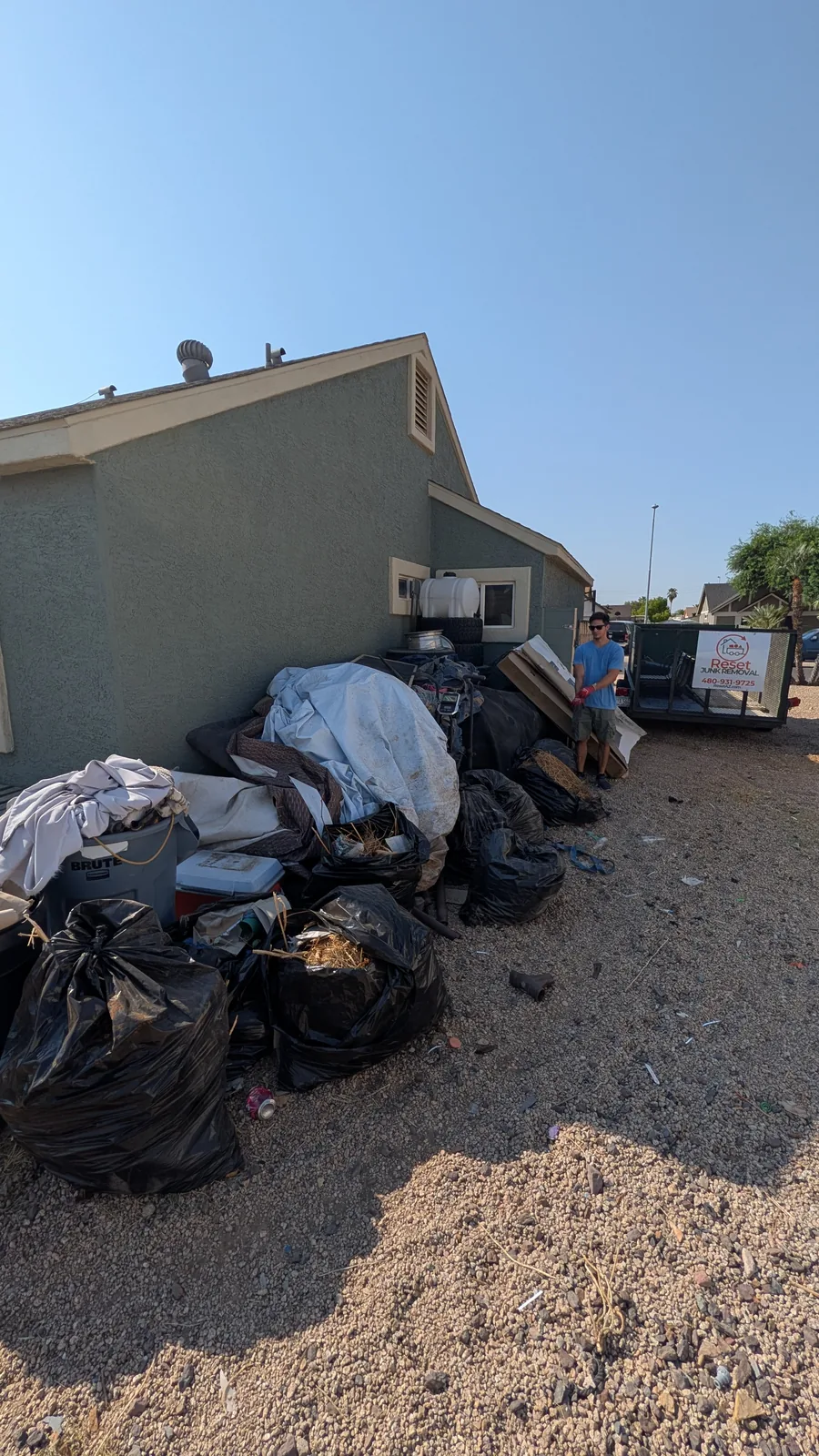 Bagged and loose bulk junk staged for removal in a Peoria side yard