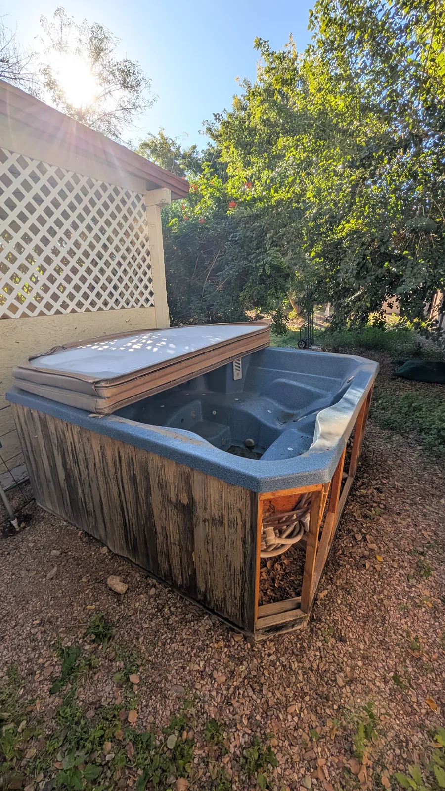 Intact hot tub in a Peoria side yard before removal